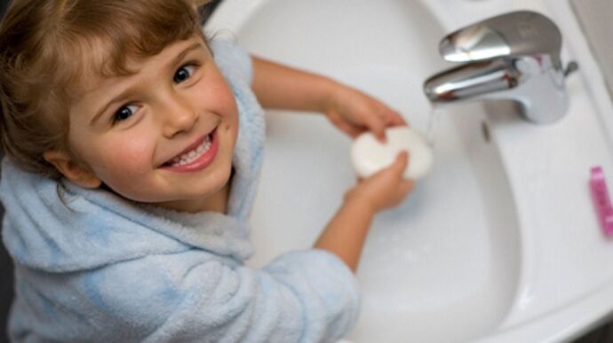 đứa trẻ rửa tay bằng xà phòng để ngừa giun